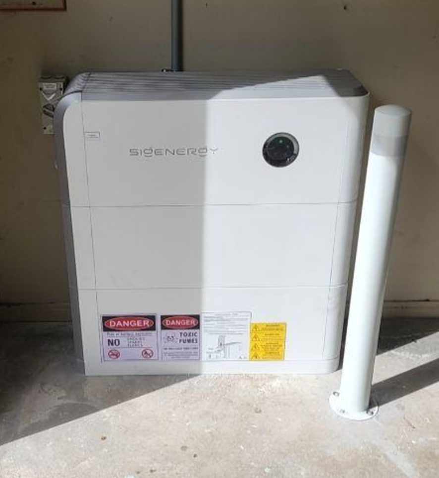 Two stacked sigenergy sigenstor battery modules standing bollard-protected on the garage floor of an aspendale gardens home