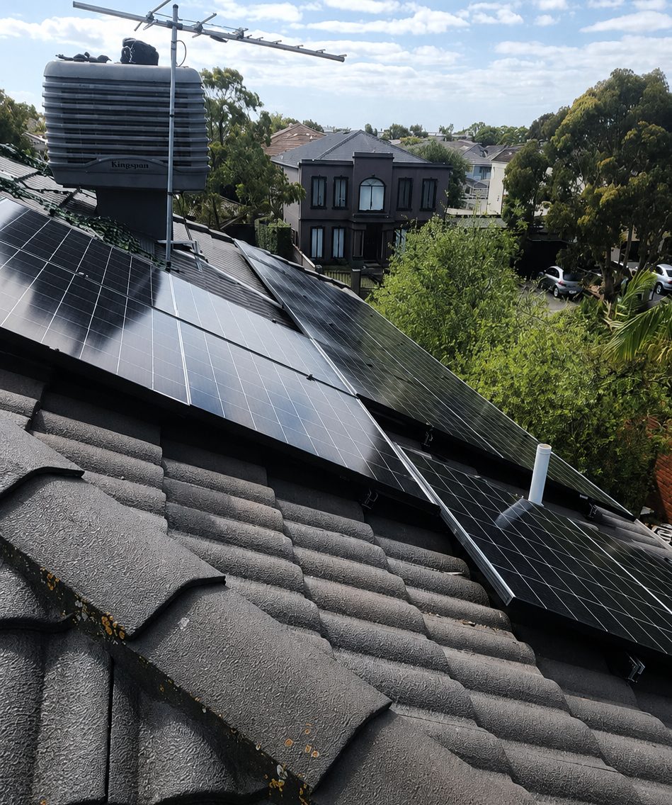 Jinko tiger neo panels across the tile roof of an aspendale gardens home, tilt-framed on the lower pitch, neighbouring houses and gums behind