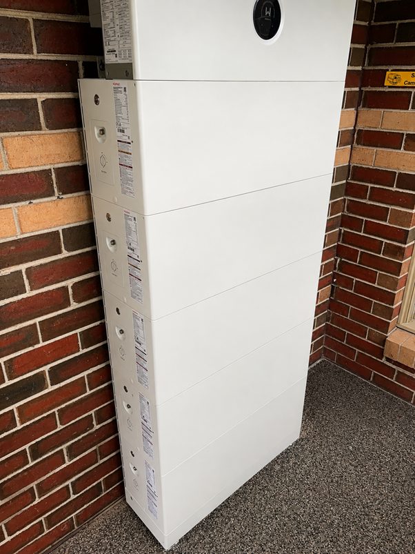 Five stacked goodwe battery modules against the brick wall of rodney's beaconsfield home