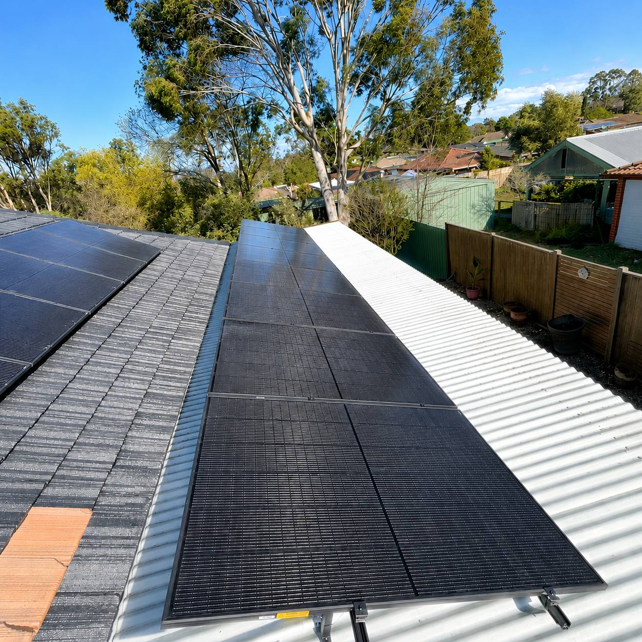 Black jinko tiger neo iii panels across the tile and tin roof of a single-storey berwick home, with one row west-tilted on the tin section