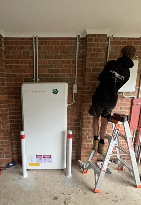 Powerband electrical installer wiring the new sigenergy sigenstor battery on the brick wall of steven's bittern home