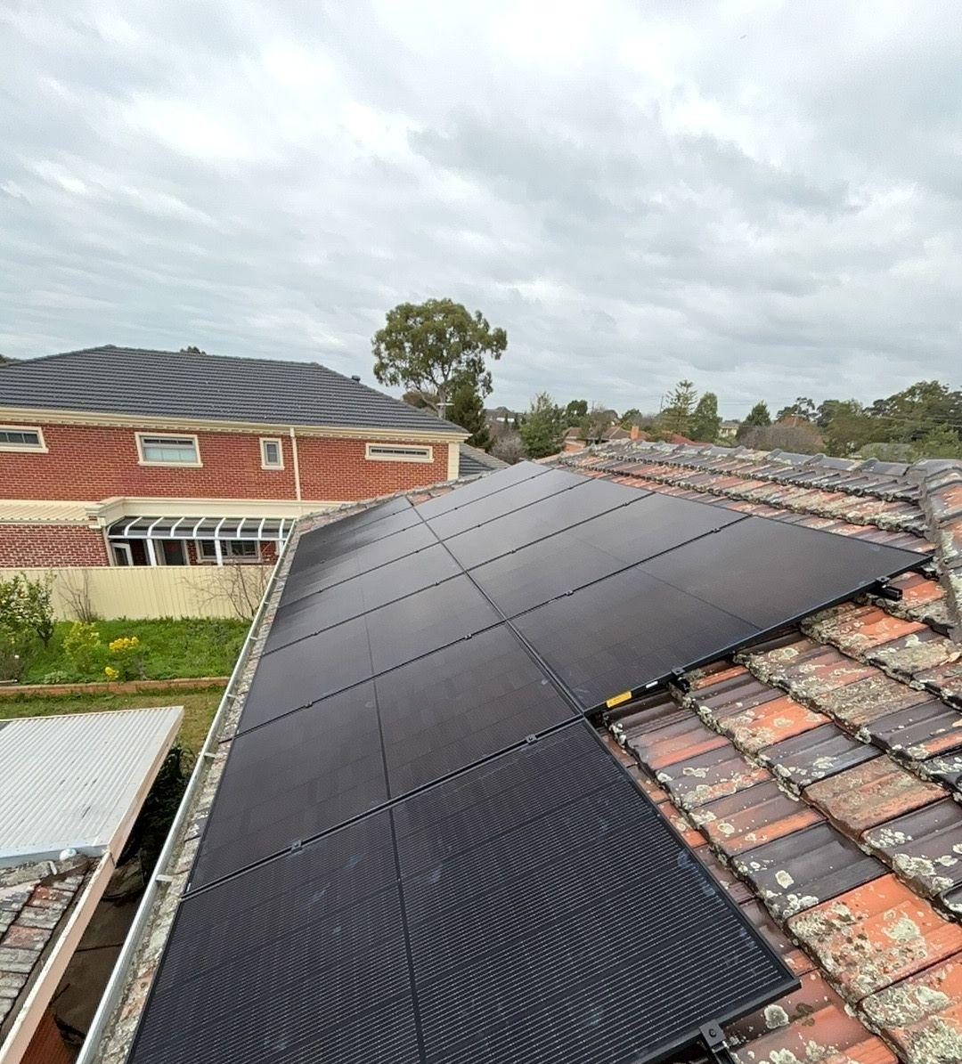 Black jinko tiger neo iii panels laid flush across the terracotta tile roof of a blackburn north home, facing east