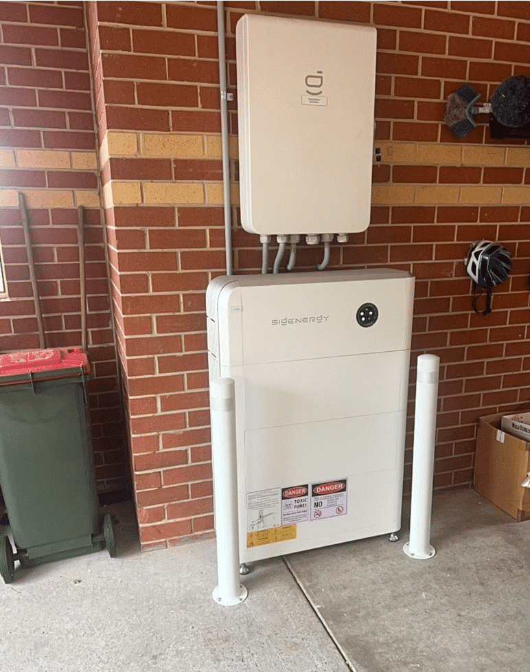 Sigenergy battery and inverter behind bollards in a berwick garage beside the switchboard