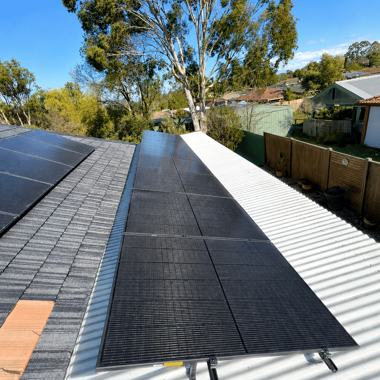 Black jinko solar panels across the tile and tin roof of a single-storey berwick home