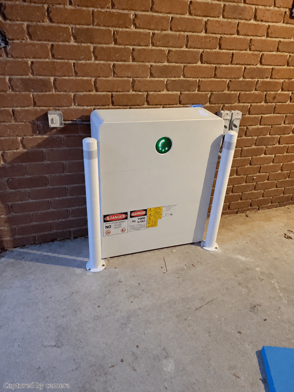 Goodwe battery behind a bollard on a brick garage wall in berwick, installed by powerband electrical