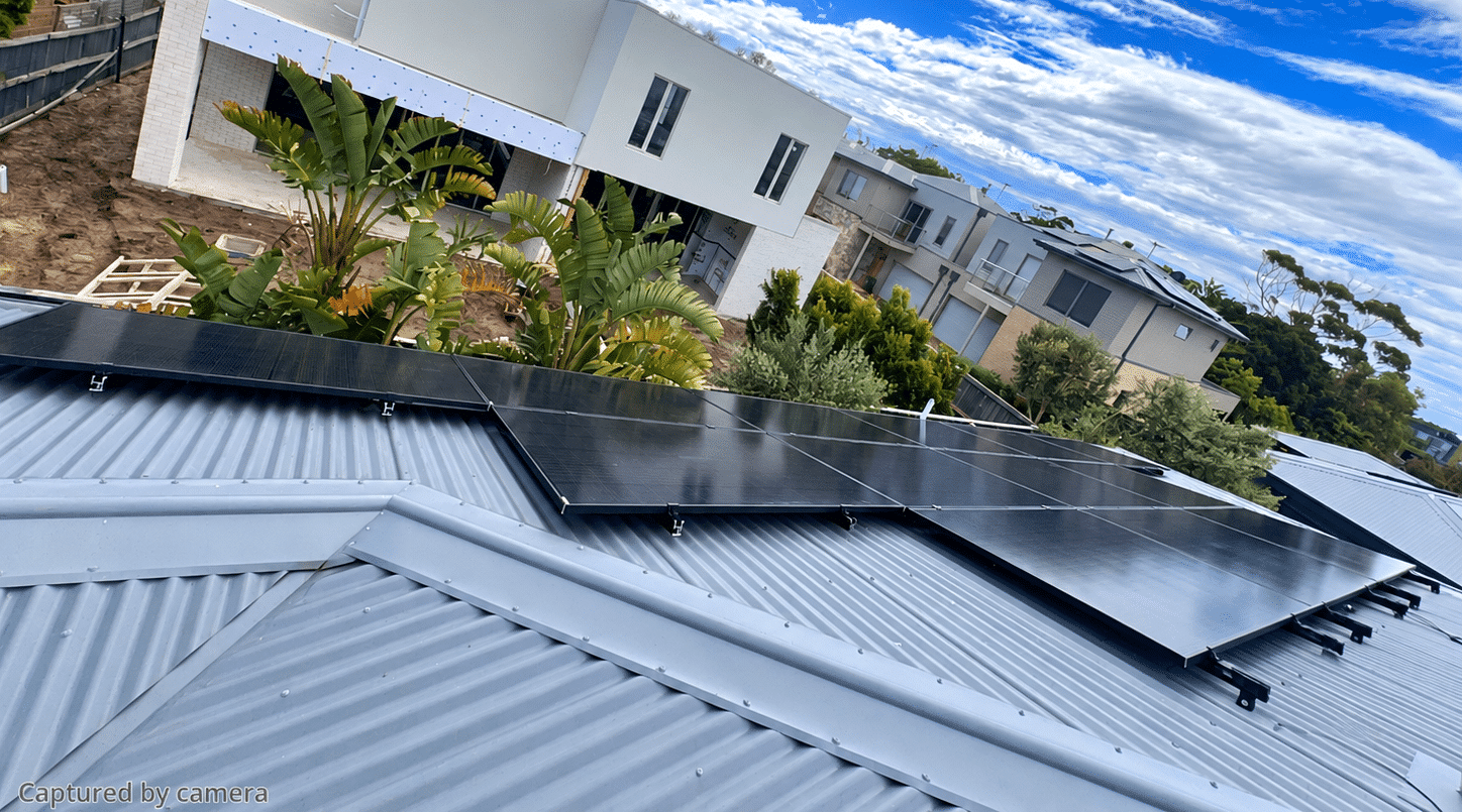 Jinko tiger neo panels across a tin roof in capel sound, new-build homes in the cul-de-sac behind