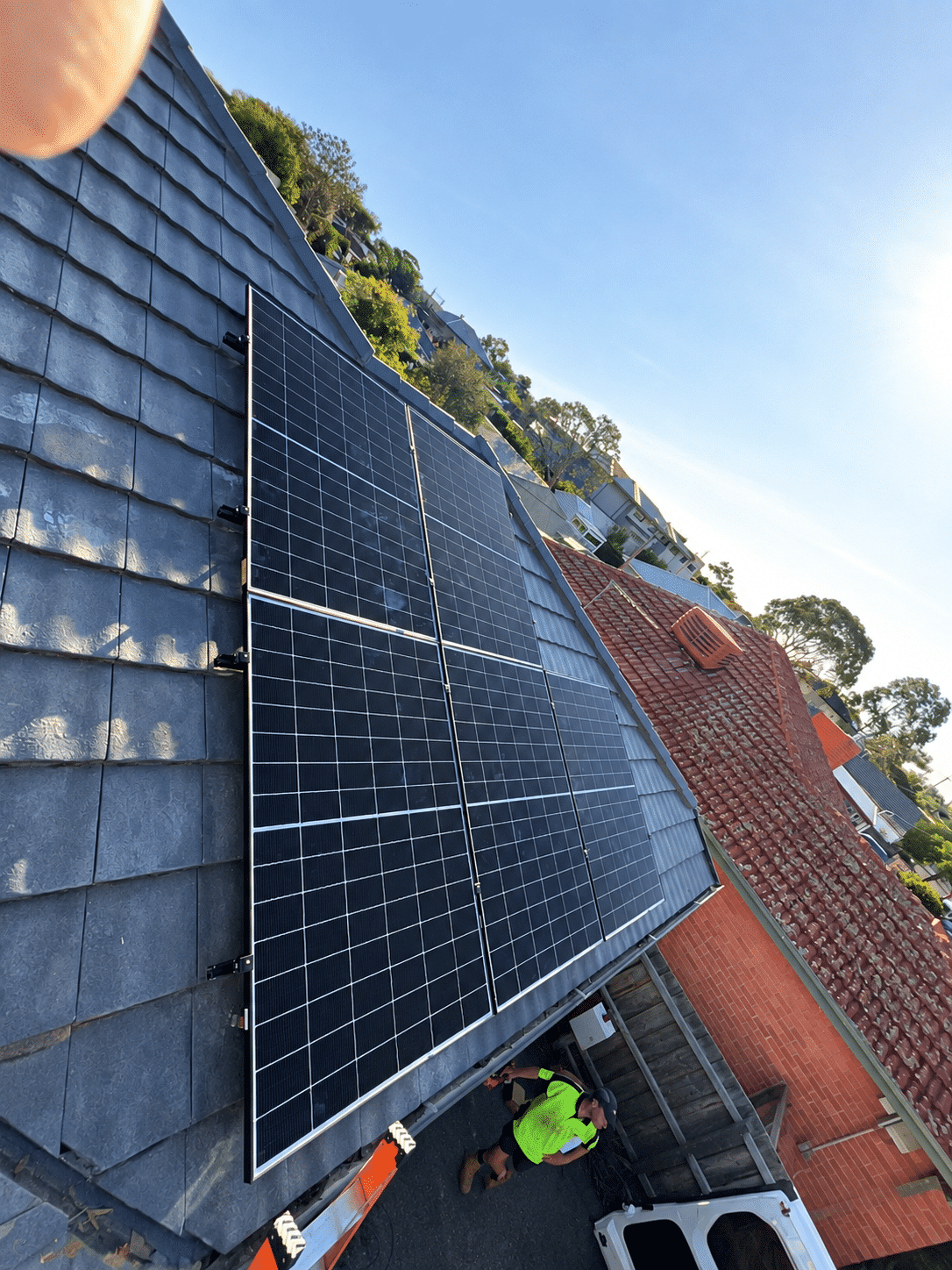 Powerband installer fitting jinko solar panels to the tile roof of a chelsea home