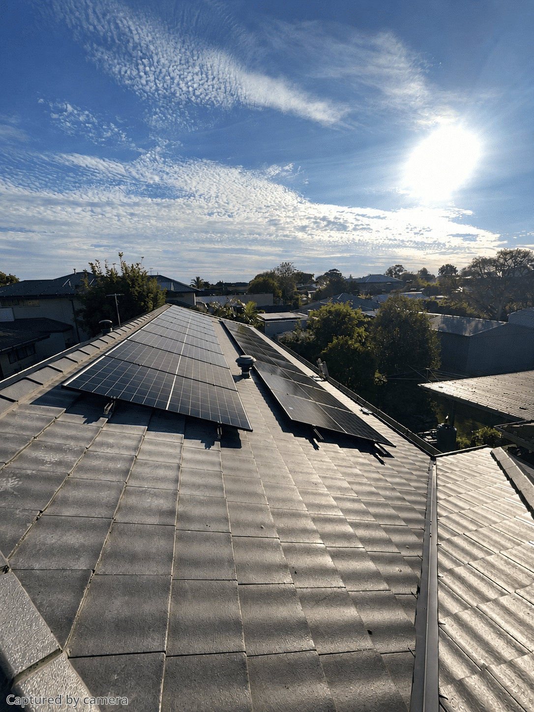Two rows of jinko solar panels on the tile roof of a chelsea home
