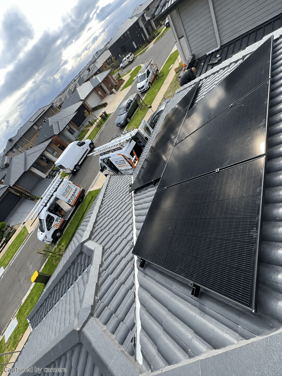 Aerial view of solar panels on a new-build home in clyde with powerband electrical vans in the street