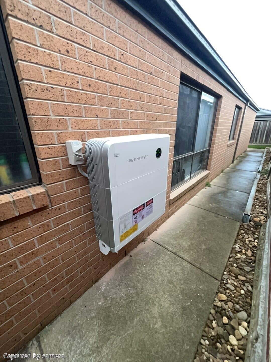 Sigenergy inverter and battery mounted on the exterior brick wall of a cranbourne north home