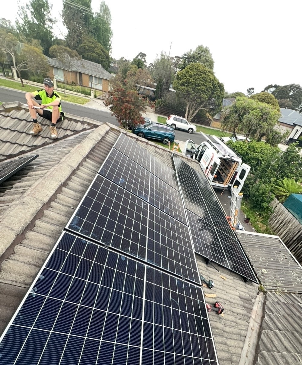 Powerband installer on a tile roof in cranbourne beside newly fitted jinko solar panels