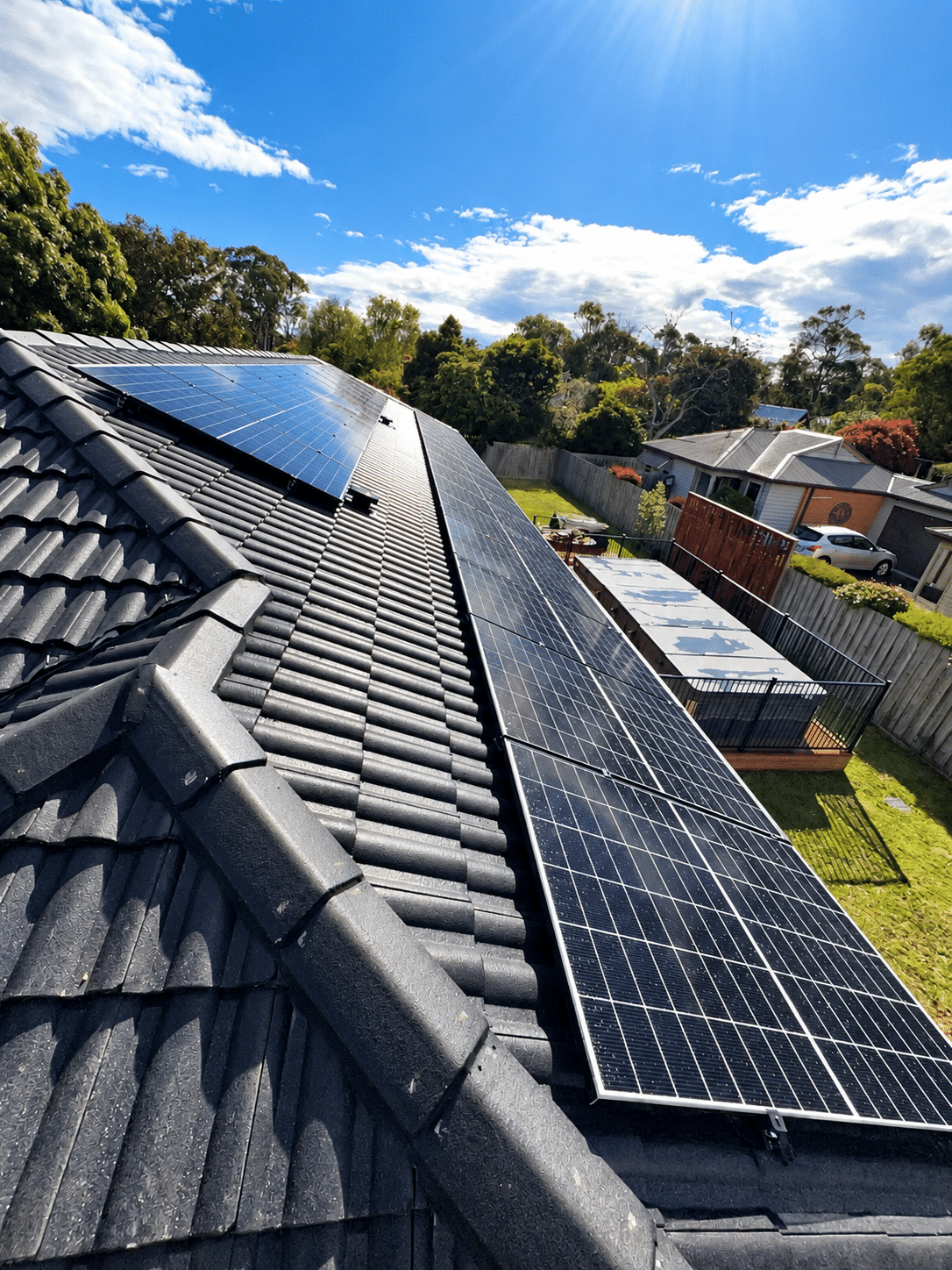 Jinko solar panels either side of the ridge on a tiled roof in crib point