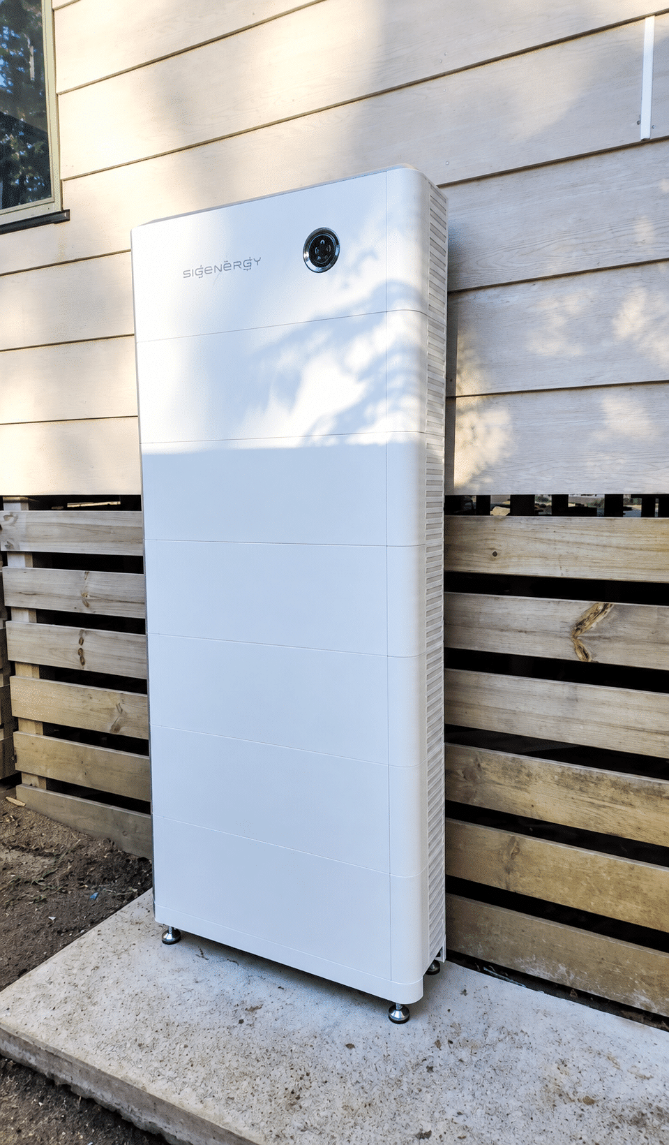 Sigenergy sigenstor battery standing against the exterior wall of a home in emerald