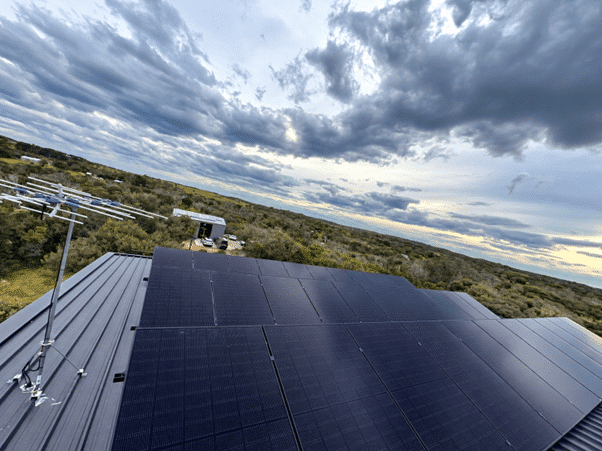 Aerial view of jinko tiger neo satin panels on a tin roof in fingal with bushland beyond