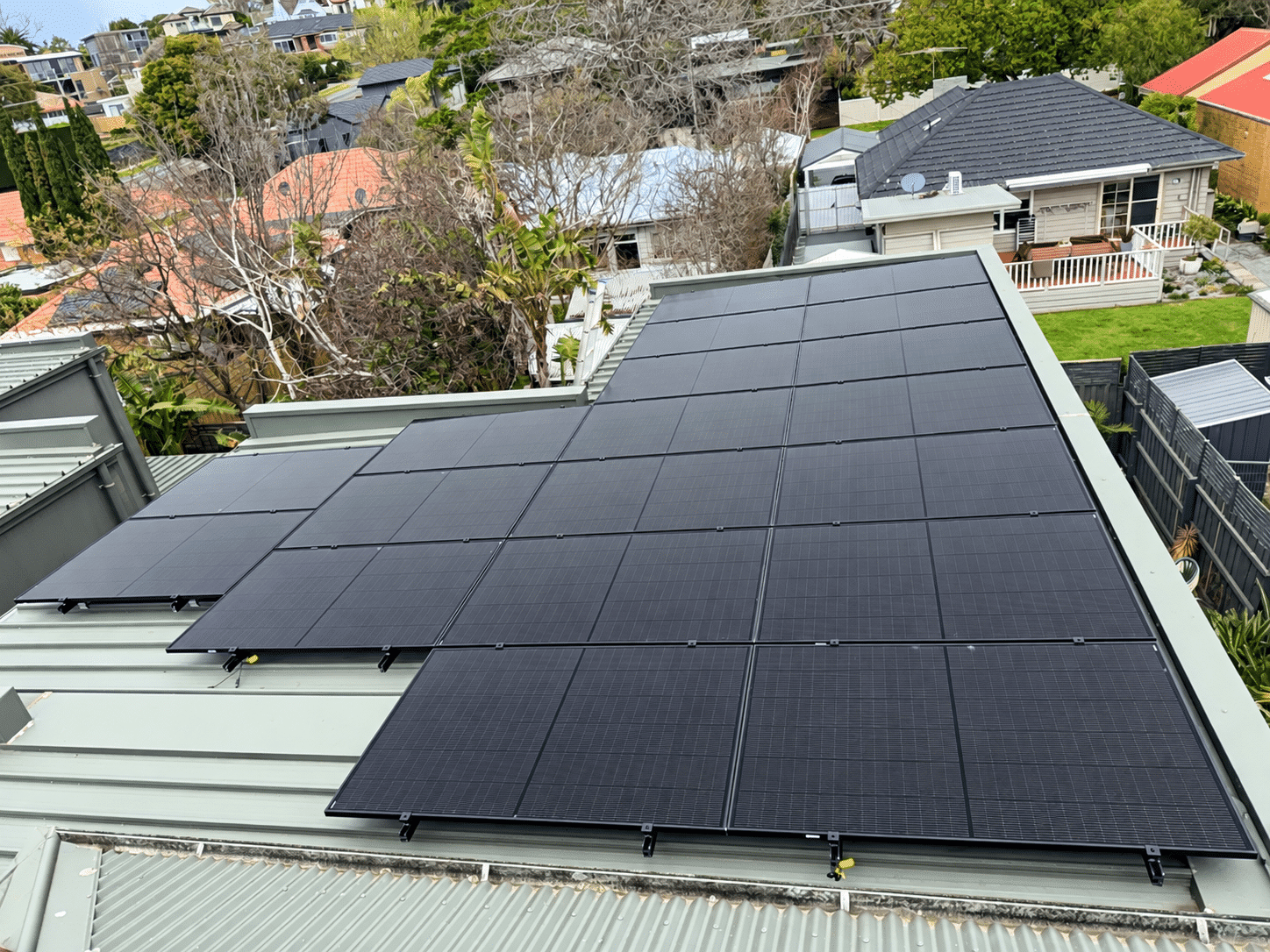 Aerial view of all-black jinko solar panels across three roof planes on a frankston south home