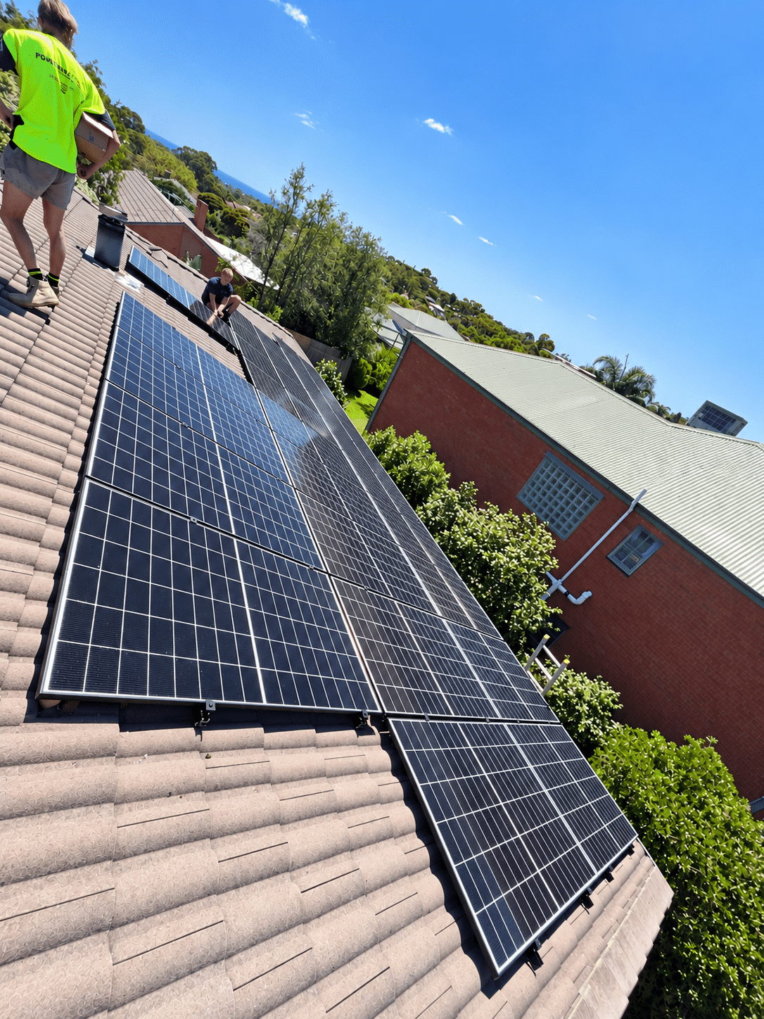 Powerband installers fitting jinko solar panels on a tile roof in frankston