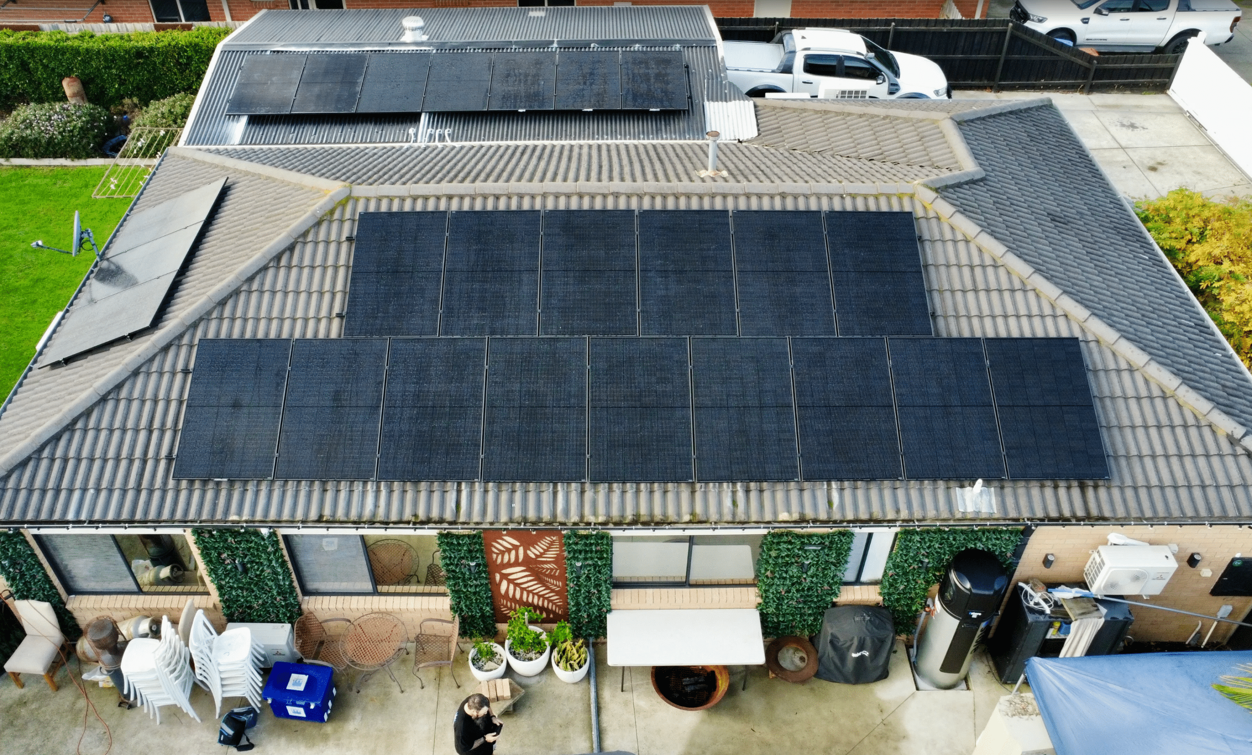 Aerial view of all-black solar panels on a tile and tin roof in hastings