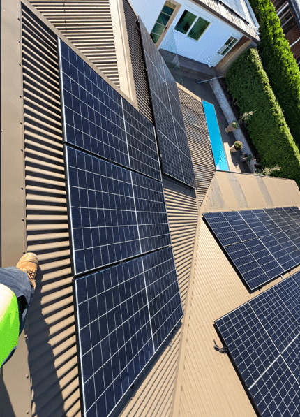 Jinko solar panels across a mount eliza roof among trees, installed by powerband electrical
