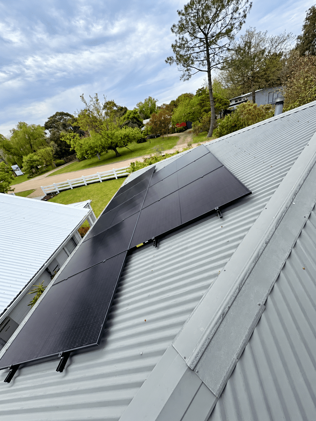 Aerial view of all-black jinko solar panels on a tin roof in mount martha