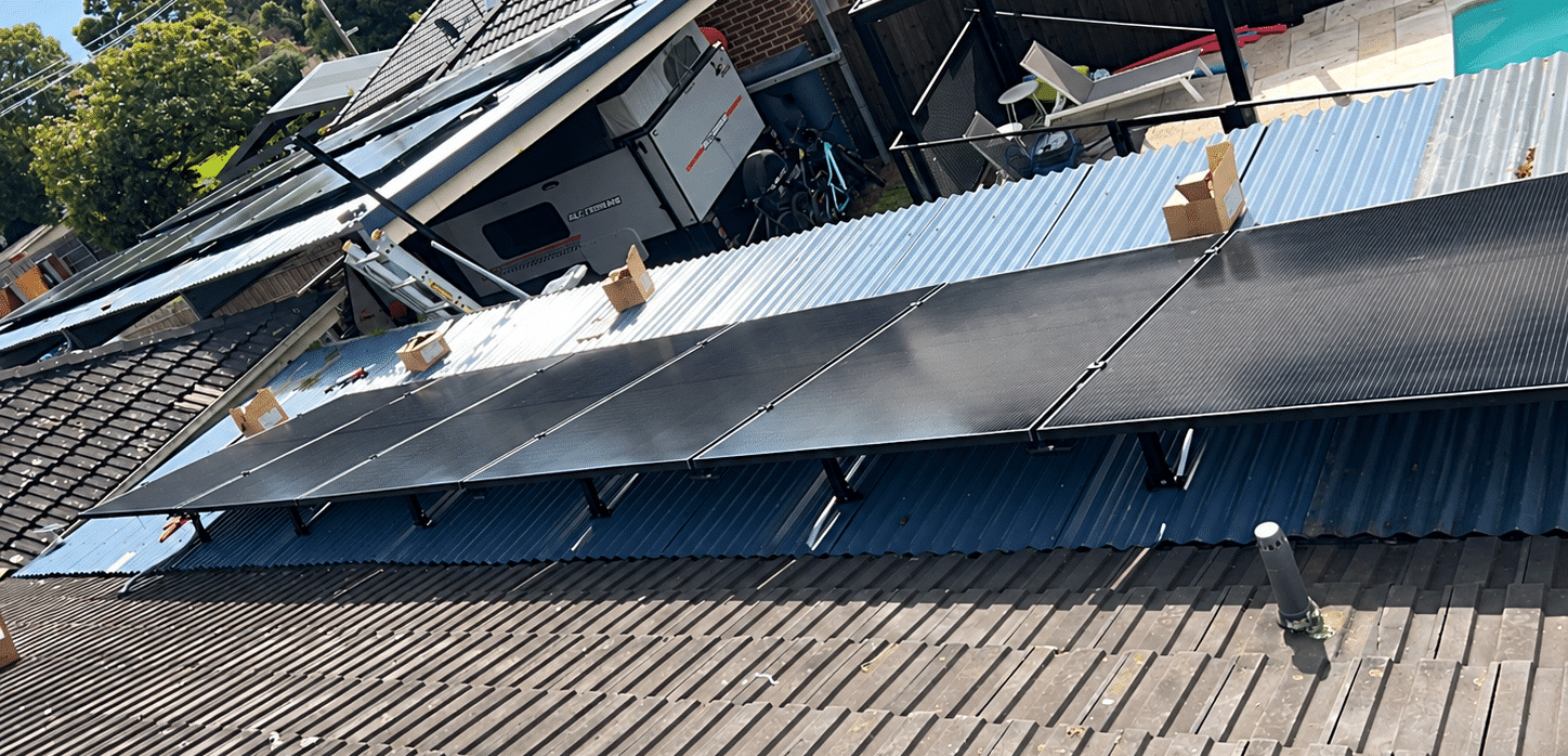 Powerband installers fitting solar panels on a somerville home with a caravan and pool below