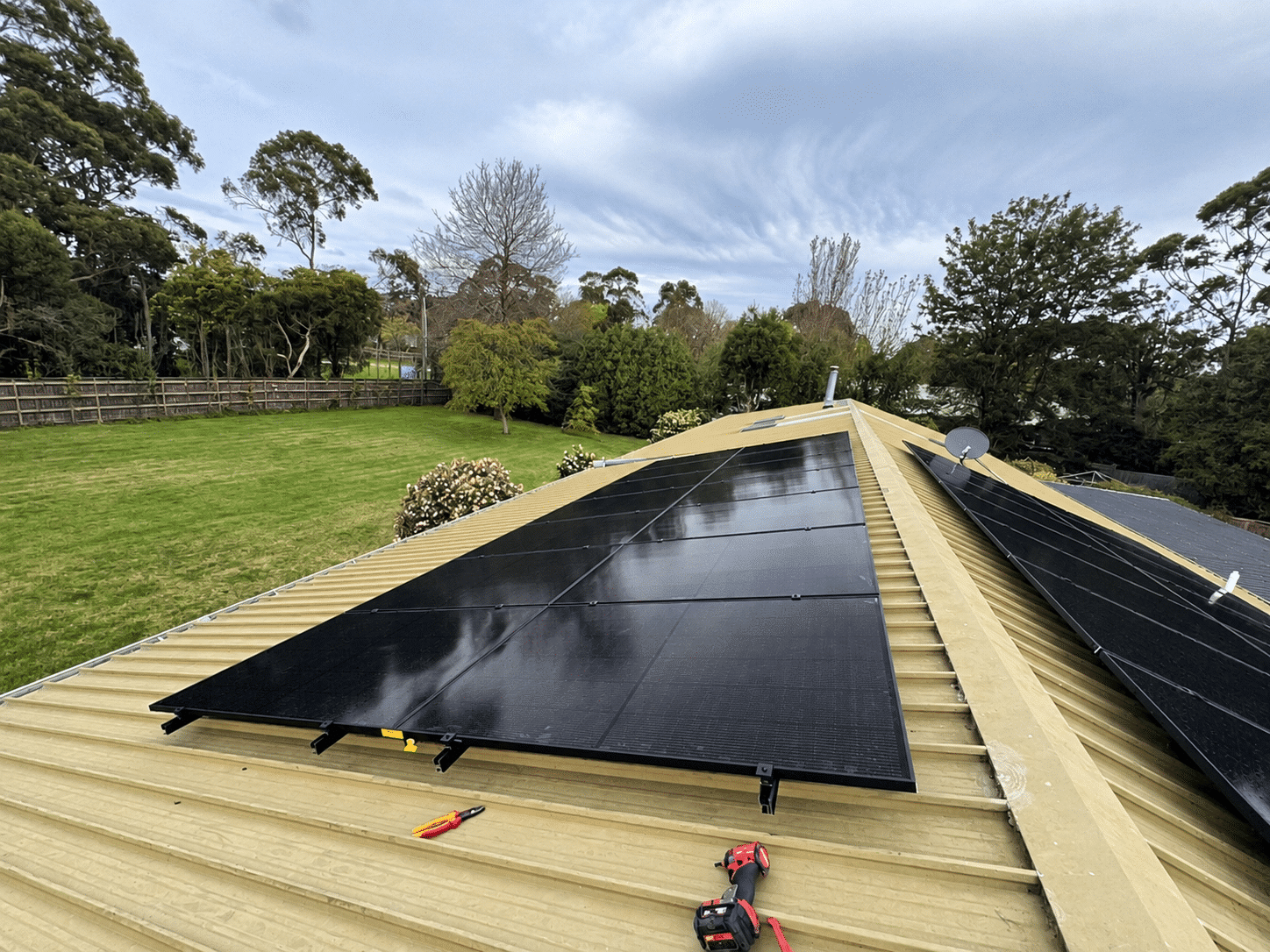 Installers fitting jinko solar panels on a metal roof in somerville