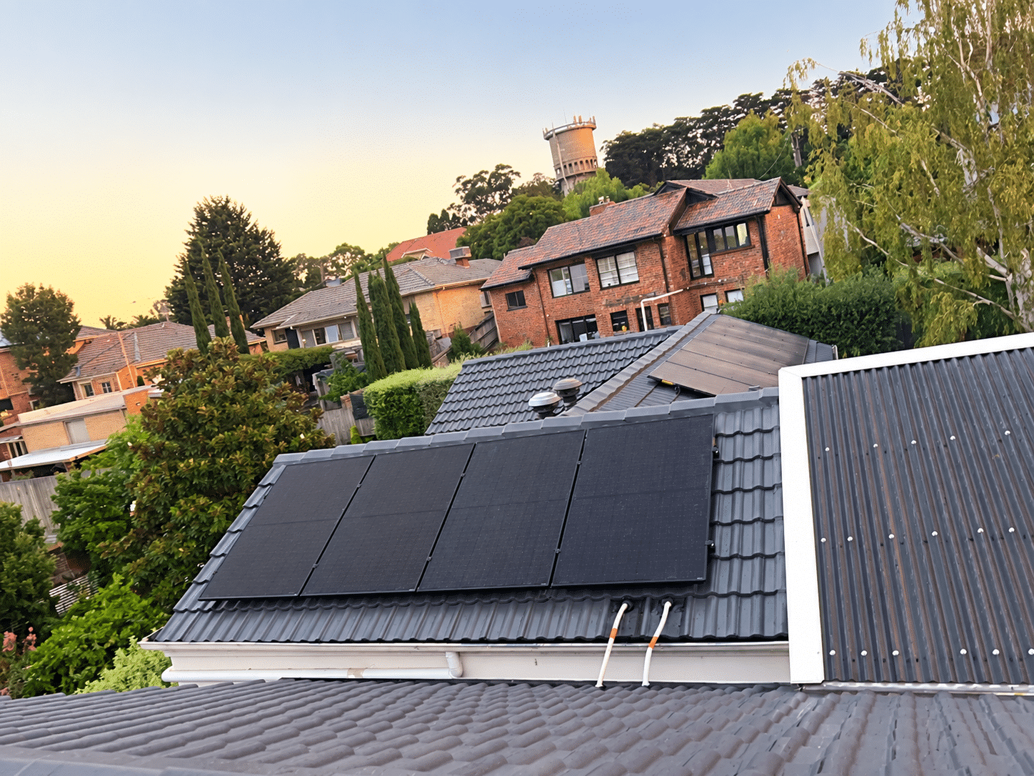 All-black solar panels on the tiled roof of a surrey hills home where split systems were also replaced