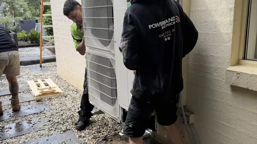 Stay Comfortable: Why Regular Hvac Maintenance Matters 3 Technicians carrying out hvac maintenance on an outdoor unit